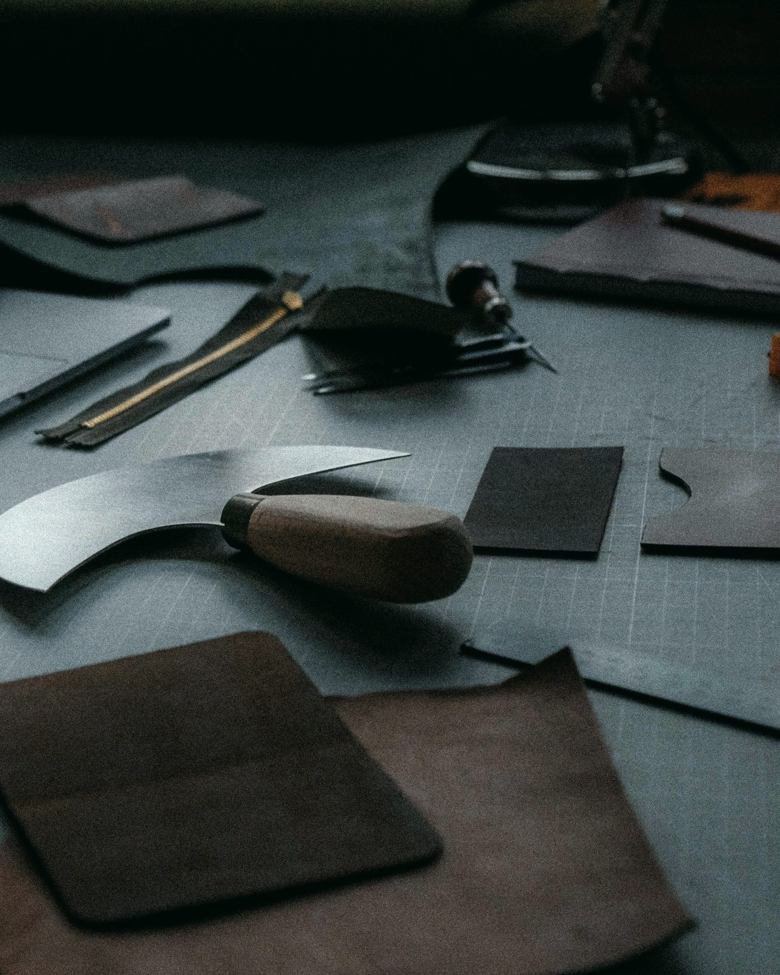 Round knife and freshly cut leather pieces on the cutting table