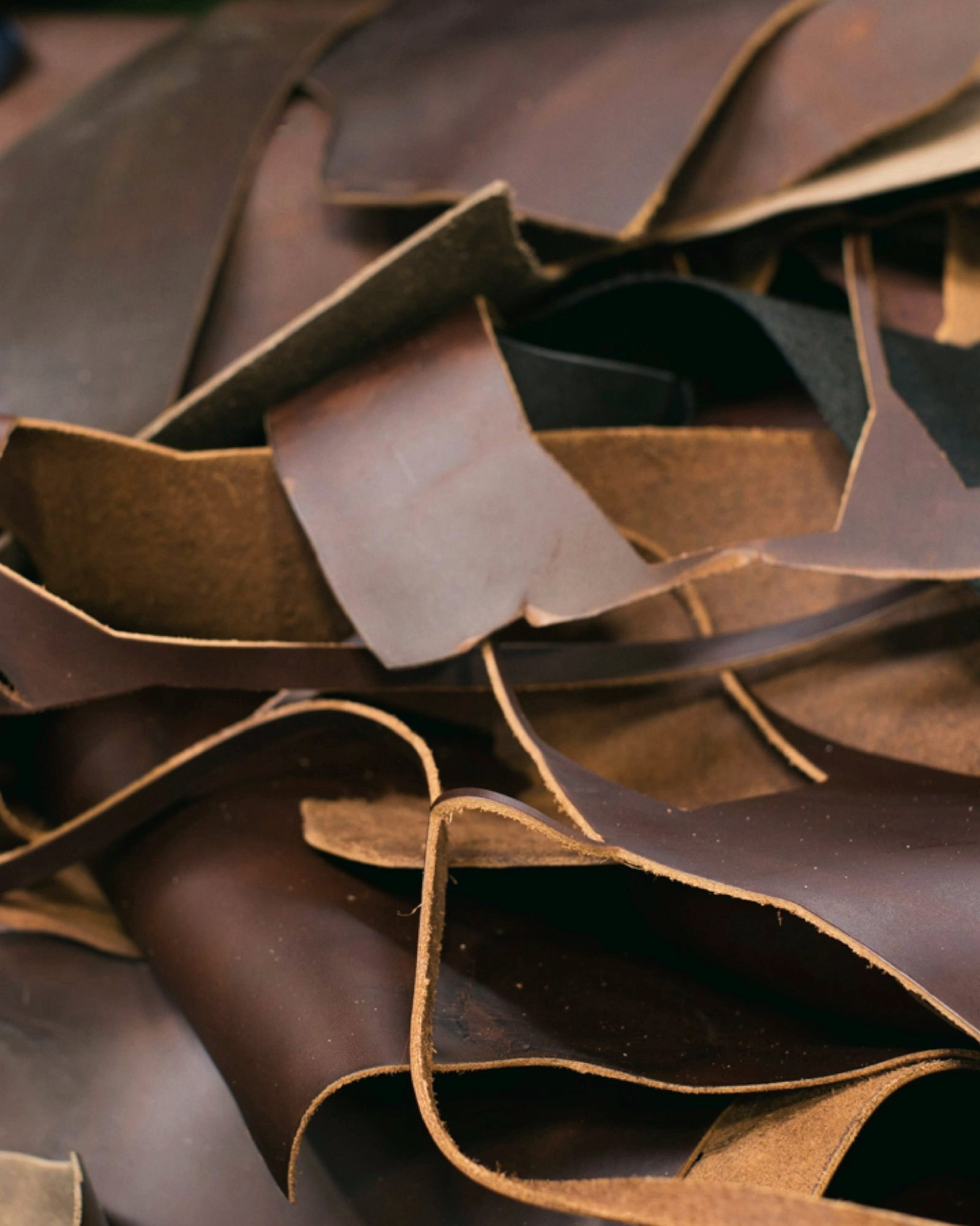 Stacked hides of brown and tan leather, chosen by hand