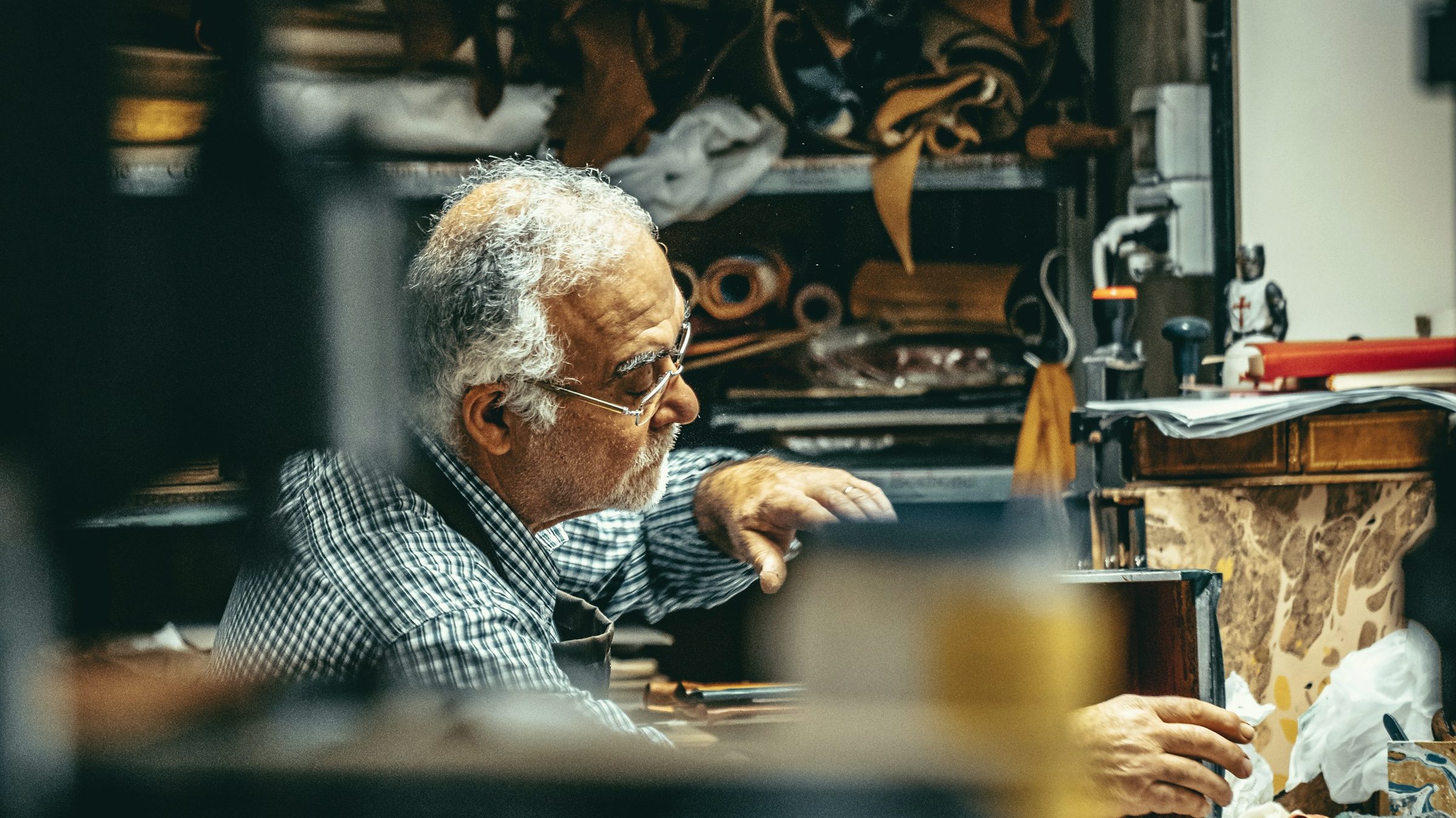 A master craftsman at his workbench in a leather workshop