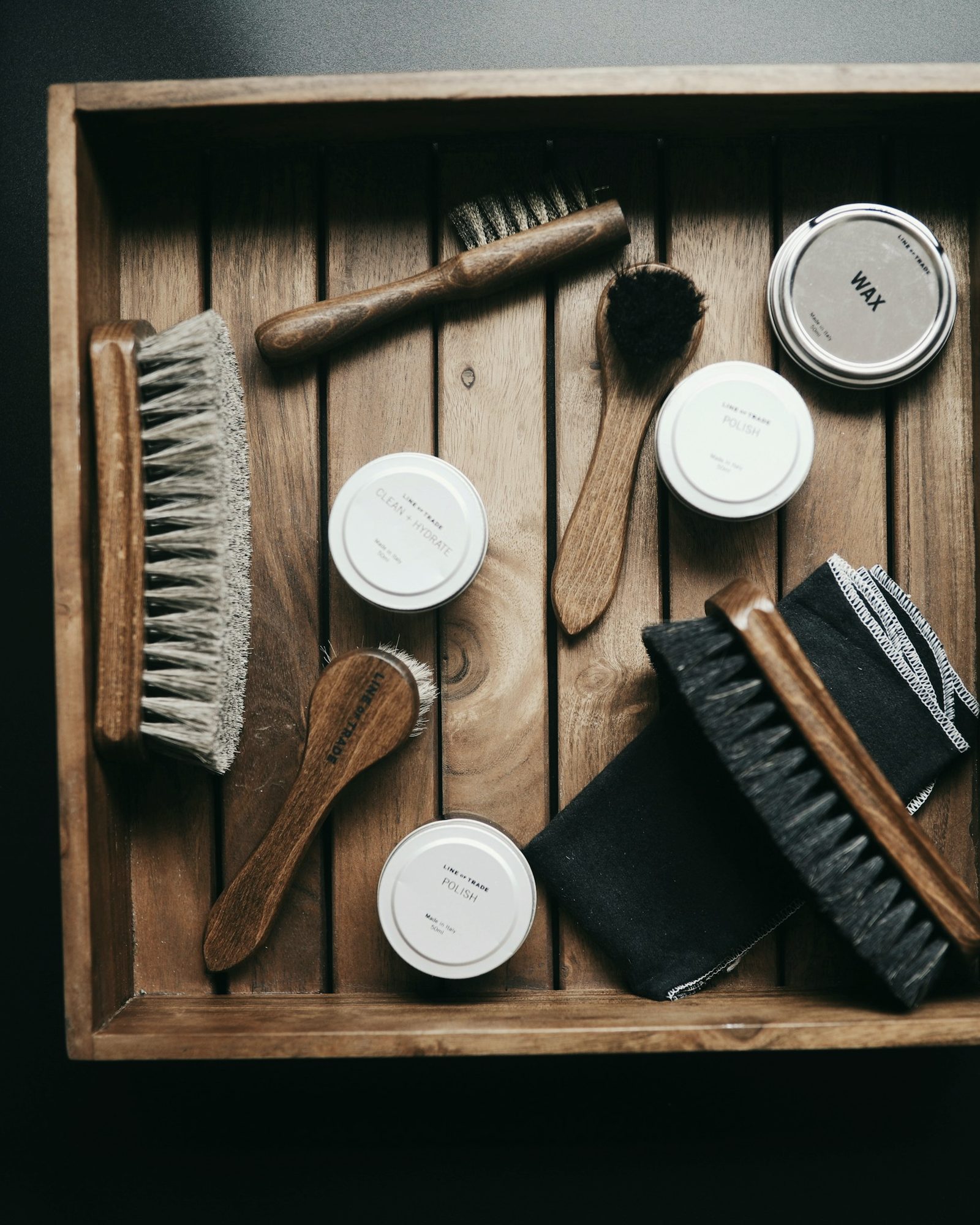 A wooden shoe-care box with brushes and polish tins