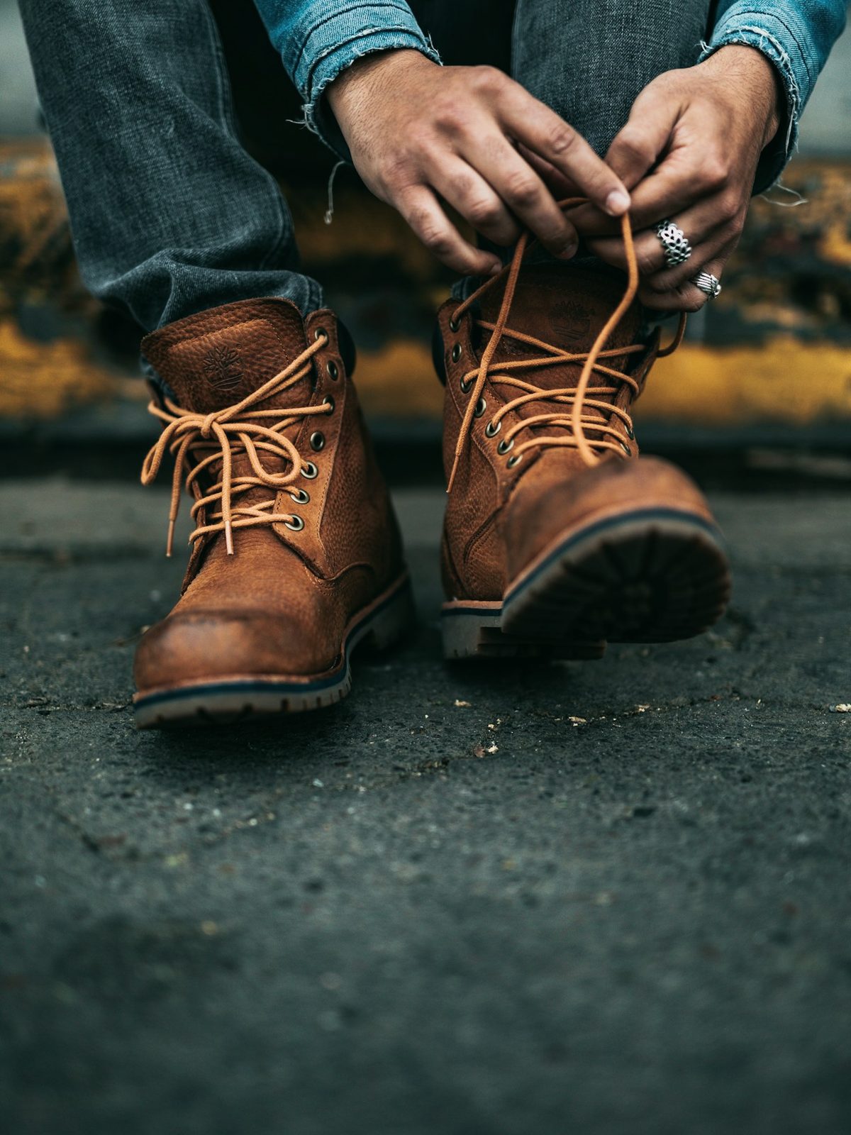 Hands lacing brown leather boots